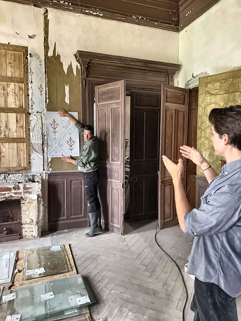 Tom and Damien planning a wallpaper restoration in a derelict room
