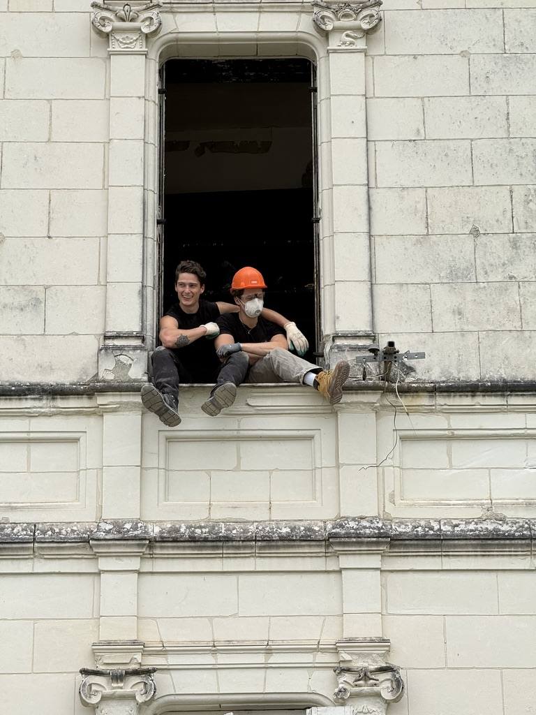 Sitting in a château window in hard hats